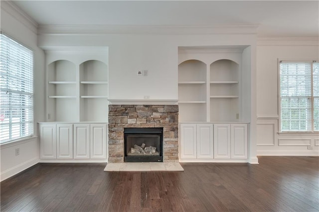 unfurnished living room featuring ornamental molding, dark hardwood / wood-style flooring, and built in features