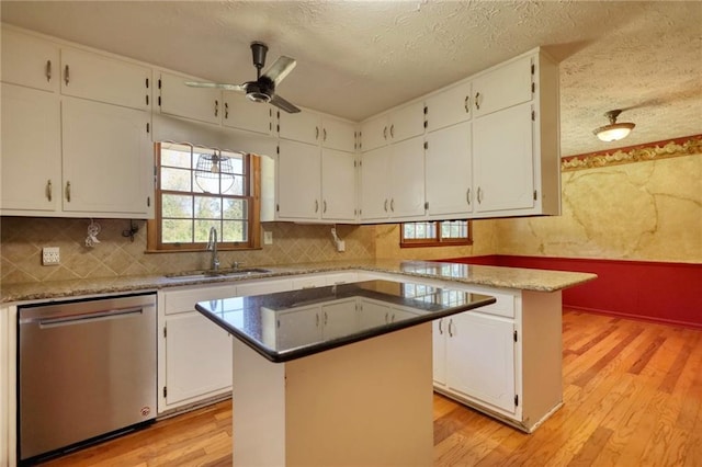 kitchen with sink, light hardwood / wood-style flooring, dishwasher, a center island, and white cabinetry