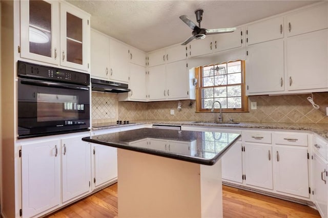 kitchen featuring sink, a center island, white cabinetry, and black appliances