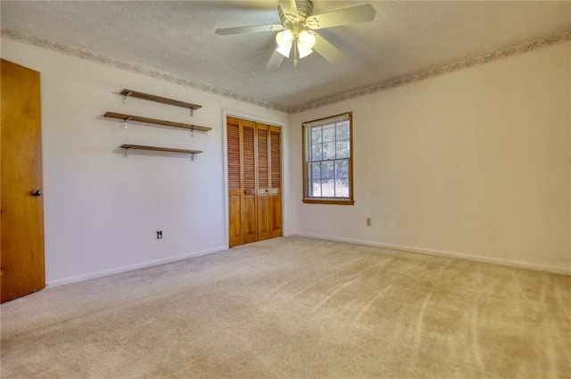 unfurnished bedroom with a closet, light colored carpet, and ceiling fan