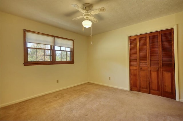 unfurnished bedroom with ceiling fan, light colored carpet, and a closet