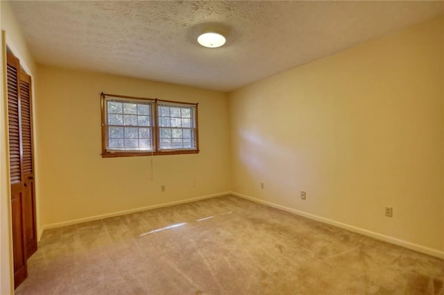 unfurnished bedroom with a textured ceiling, light carpet, and a closet