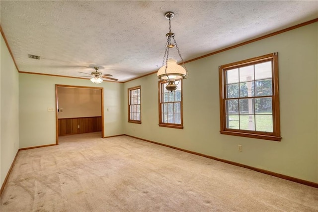 unfurnished room with ceiling fan, light colored carpet, a textured ceiling, and ornamental molding