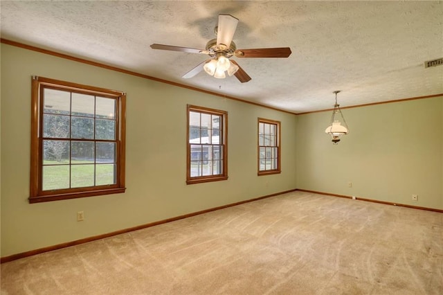 unfurnished room featuring ceiling fan, light colored carpet, ornamental molding, and a textured ceiling