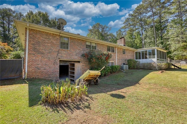 back of property featuring a sunroom, a yard, and cooling unit