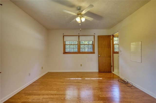 spare room with a textured ceiling, light hardwood / wood-style floors, and ceiling fan