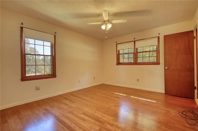 unfurnished room featuring a textured ceiling, light wood-type flooring, and ceiling fan