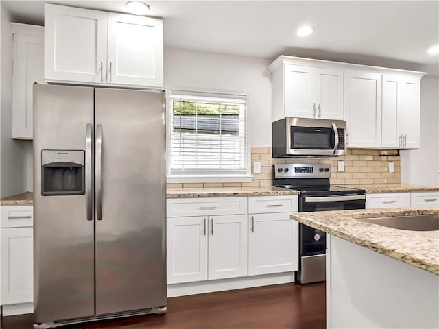 644 Albert St NW, Atlanta, GA 30318 - kitchen featuring stainless steel appliances, white cabinets, dark wood finished floors, decorative backsplash, and light stone counters