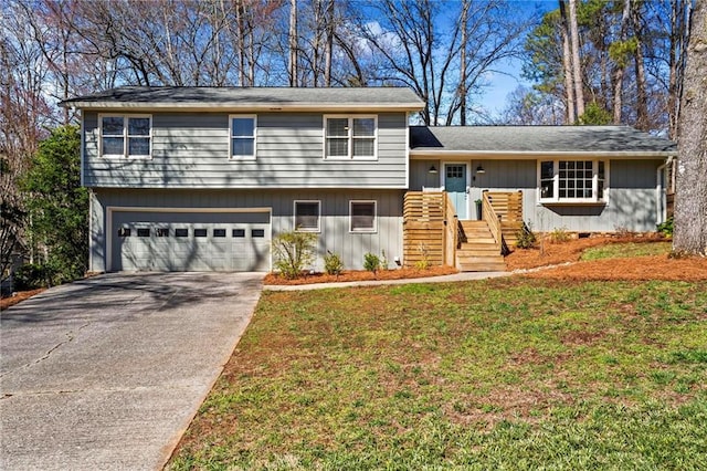 split level home with a front lawn, an attached garage, and concrete driveway