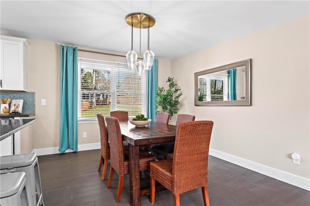 dining area with dark wood finished floors, an inviting chandelier, and baseboards