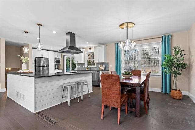 dining space with plenty of natural light, dark wood-style floors, and baseboards