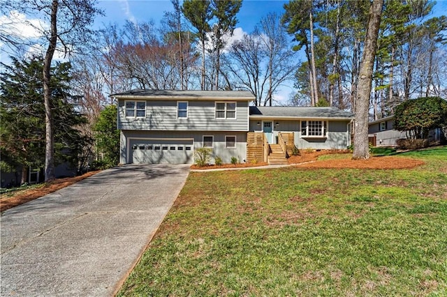 split level home with an attached garage, concrete driveway, and a front yard