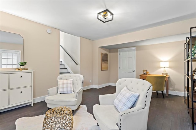 sitting room with baseboards, stairs, and dark wood-type flooring