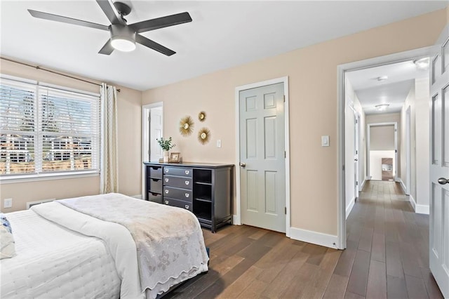 bedroom with dark wood-style floors, ceiling fan, and baseboards