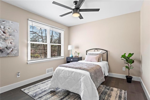 bedroom featuring visible vents, baseboards, wood finished floors, and a ceiling fan