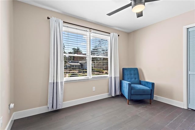 sitting room with baseboards, wood finished floors, and a ceiling fan