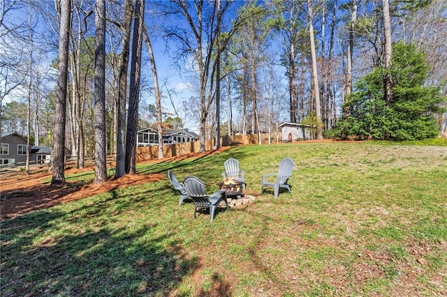 view of yard with fence and an outdoor fire pit