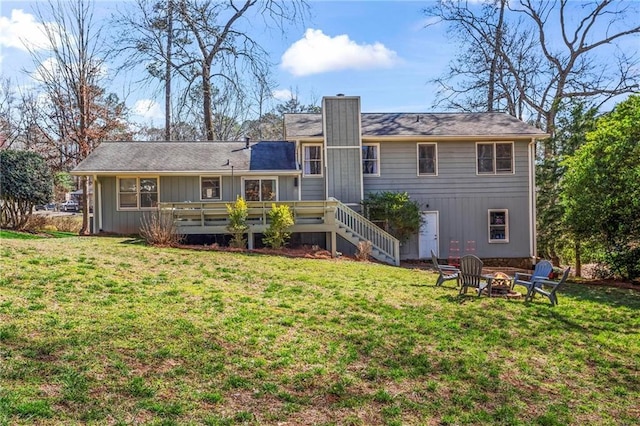 back of property with a wooden deck, a lawn, stairs, and an outdoor fire pit