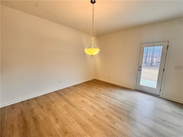 spare room featuring light wood-style floors and baseboards