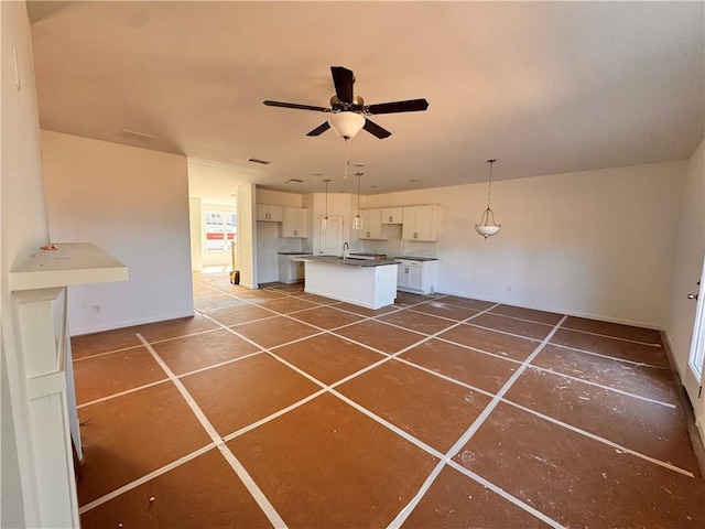 kitchen with sink, a center island, hanging light fixtures, ceiling fan, and white cabinets