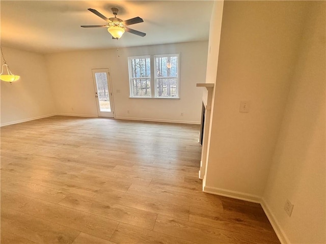 unfurnished living room featuring light wood-style floors, a fireplace, baseboards, and a ceiling fan