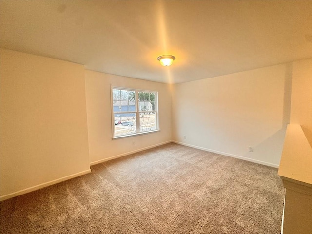 empty room featuring carpet floors and baseboards