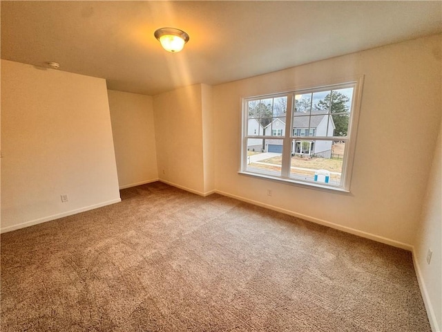 unfurnished room featuring carpet floors and baseboards