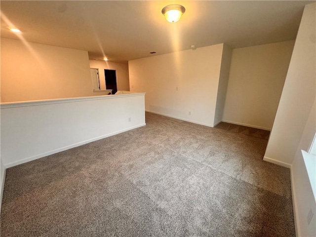 empty room featuring carpet and baseboards