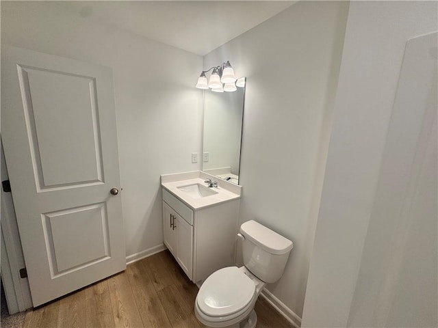 bathroom featuring vanity, wood finished floors, toilet, and baseboards