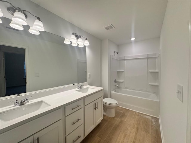 full bathroom featuring visible vents, a sink, toilet, and wood finished floors