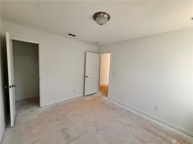 unfurnished bedroom featuring a walk in closet and a closet