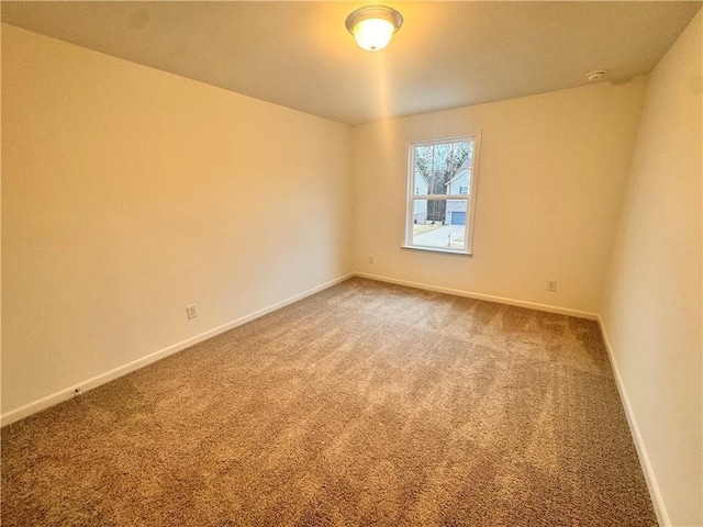 empty room featuring carpet and baseboards