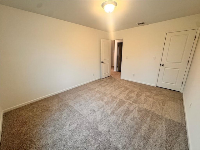 unfurnished bedroom with carpet, visible vents, and baseboards