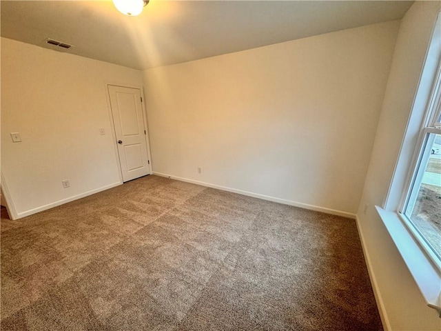 carpeted empty room featuring baseboards