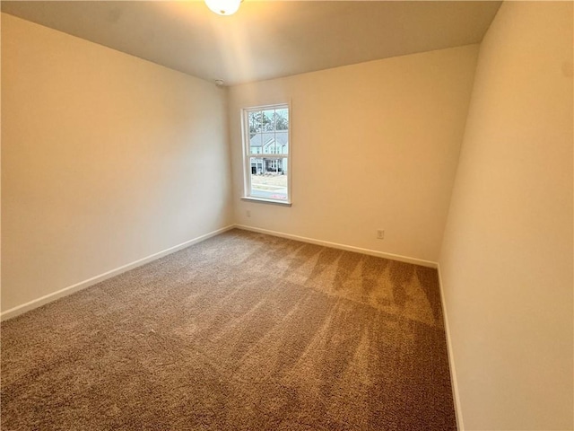 empty room featuring carpet floors and baseboards