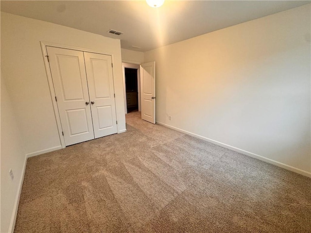 unfurnished bedroom featuring carpet, visible vents, and baseboards