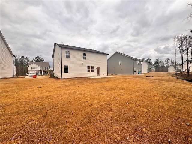 rear view of house featuring a yard and a patio