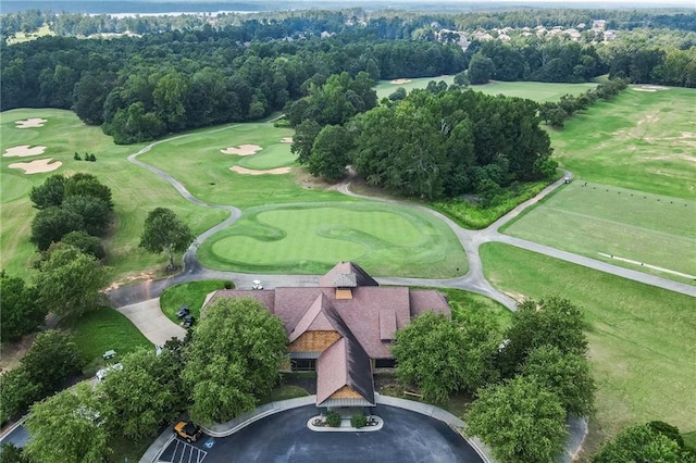 drone / aerial view featuring view of golf course and a view of trees