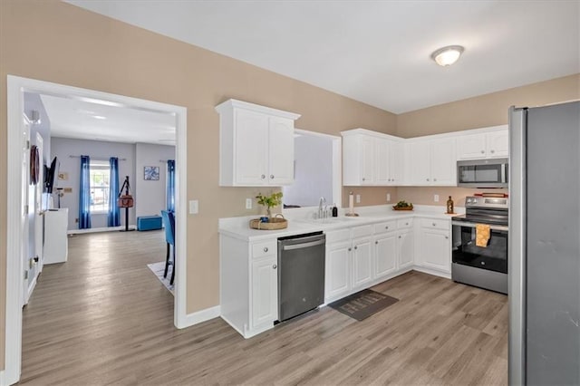 261 Venture Path, Hiram, GA 30141 - kitchen with stainless steel appliances, light wood-type flooring, white cabinetry, and light countertops