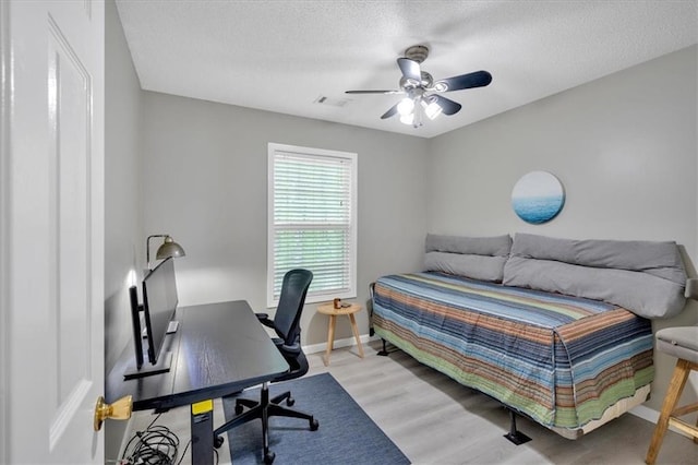 261 Venture Path, Hiram, GA 30141 - bedroom with a desk, light wood finished floors, a textured ceiling, and a ceiling fan