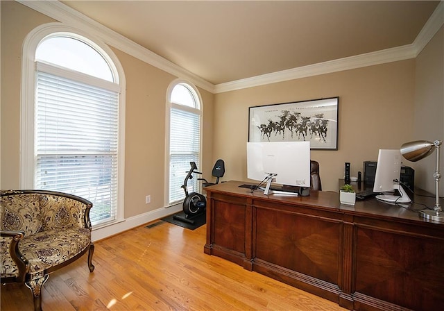 home office featuring ornamental molding, light wood-type flooring, visible vents, and baseboards