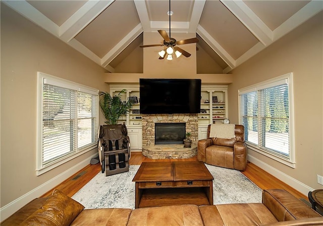 living room featuring a fireplace, beam ceiling, and wood finished floors