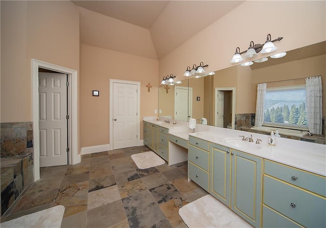 bathroom with high vaulted ceiling, two vanities, a sink, and baseboards