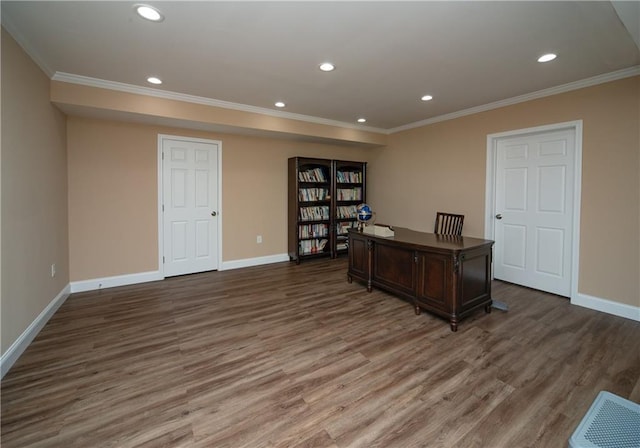 office area with crown molding, visible vents, and wood finished floors