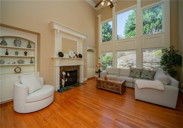 sunroom featuring ceiling fan and a high end fireplace