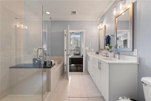 full bathroom featuring vanity, toilet, shower with separate bathtub, and tile patterned flooring