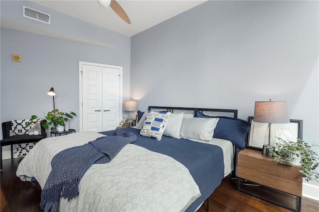 bedroom featuring wood-type flooring, visible vents, ceiling fan, and a closet