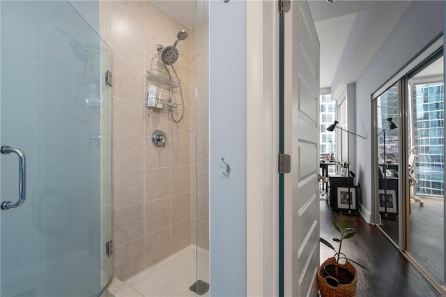 bathroom with a stall shower and wood finished floors