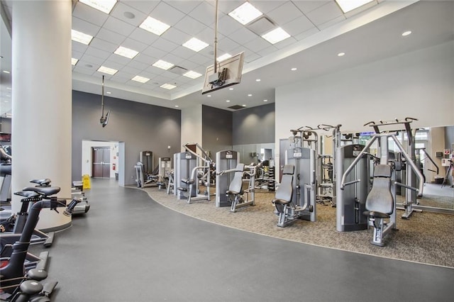 exercise room with a drop ceiling and a towering ceiling