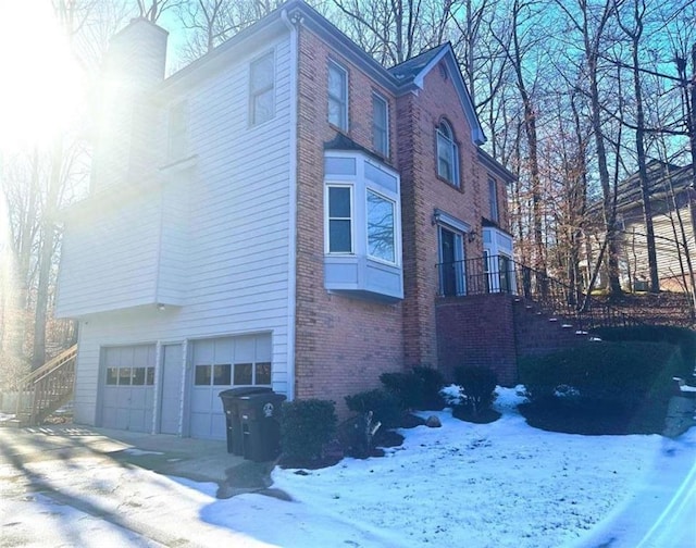 snow covered property with a garage